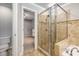 A bathroom featuring a glass-enclosed shower, a bathtub, and access to the walk-in closet at 11302 Musette Cir, Alpharetta, GA 30009