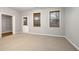 Spacious bedroom with carpet floors, two windows with blinds, and a door leading to the outside at 11302 Musette Cir, Alpharetta, GA 30009