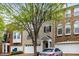 Inviting townhome featuring a garage and classic brick exterior with a well-manicured lawn at 11302 Musette Cir, Alpharetta, GA 30009