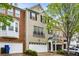 Charming townhome featuring brick and gray painted facade, complemented by an attached two-car garage and tasteful landscaping at 11302 Musette Cir, Alpharetta, GA 30009