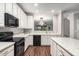 Bright kitchen featuring stainless steel appliances, granite countertops, and white cabinets at 11302 Musette Cir, Alpharetta, GA 30009