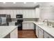 Modern kitchen features white cabinets, granite countertops, stainless steel appliances, and hardwood floors at 11302 Musette Cir, Alpharetta, GA 30009