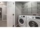 Convenient laundry room featuring a newer washer and dryer plus ample shelving at 11302 Musette Cir, Alpharetta, GA 30009