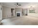 Open-concept living room with fireplace, carpet, and large window showcasing ample space at 11302 Musette Cir, Alpharetta, GA 30009