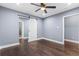 A bedroom featuring dark hardwood floors, a ceiling fan, and a white barn door at 1441 Cahaba Sw Dr, Atlanta, GA 30311
