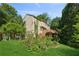 A backyard shows a two-story house with a wooden deck and steps, plus a tiered garden and lush trees at 2500 Kingsbrooke Ln, Duluth, GA 30097