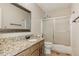 Bathroom features a shower with sliding glass doors, granite countertop, and wood-trimmed mirror at 2500 Kingsbrooke Ln, Duluth, GA 30097