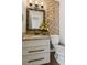 Charming half bath with granite counters, a decorative mirror, and a brick accent wall at 2500 Kingsbrooke Ln, Duluth, GA 30097