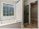 Bright bathroom featuring a separate shower, tub, and walk in closet at 2500 Kingsbrooke Ln, Duluth, GA 30097