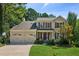 Inviting two-story home featuring a well-kept lawn and attached two-car garage at 2500 Kingsbrooke Ln, Duluth, GA 30097