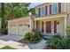 Charming home with a two-car garage, red shutters, and a well-manicured lawn and garden at 2500 Kingsbrooke Ln, Duluth, GA 30097