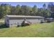Extensive backyard featuring a deck, lush green grass, and mature trees at 537 Craven Rd, Roopville, GA 30170