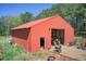 Exterior of a red metal barn with a tractor and other equipment parked outside at 537 Craven Rd, Roopville, GA 30170