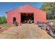 Features a red metal barn with a large open bay and various equipment inside, perfect for storage and projects at 537 Craven Rd, Roopville, GA 30170