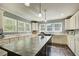 Bright kitchen with white cabinets, lots of counter space and cabinetry, and modern lighting fixtures at 537 Craven Rd, Roopville, GA 30170