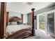 Main bedroom featuring a four-poster bed, carpet flooring, a walk out to the patio and cozy design at 537 Craven Rd, Roopville, GA 30170