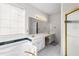 Bright bathroom featuring a tub, white cabinets, and a large mirror with vanity lighting at 5494 White Cedar Ter, Sugar Hill, GA 30518