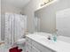 Bathroom has a vanity, mirror, white shower curtain with an intricate print, and white tiled walls at 5494 White Cedar Ter, Sugar Hill, GA 30518