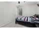 This cozy bedroom has neutral walls, a black frame bed and natural light from the window at 5494 White Cedar Ter, Sugar Hill, GA 30518