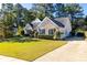 Inviting brick home with lush green lawn, showcasing the driveway and attached two car garage at 5494 White Cedar Ter, Sugar Hill, GA 30518