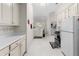 Spacious kitchen with white appliances and cabinets, with adjacent laundry room at 5494 White Cedar Ter, Sugar Hill, GA 30518