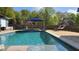 Beautiful backyard pool with a water feature, blue umbrellas, and lounge chairs for relaxation and enjoyment at 4118 Sandy Branch Dr, Buford, GA 30519