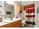 Bathroom with a tub and shower, granite-style countertop, and wood cabinets at 135 Fiddle Crk, Social Circle, GA 30025
