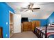 Bedroom with blue accent wall features a ceiling fan and carpeted floors at 135 Fiddle Crk, Social Circle, GA 30025