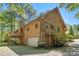 Exterior of the home featuring a garage, balcony, and mature trees at 135 Fiddle Crk, Social Circle, GA 30025