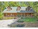 Charming log cabin home with inviting front porch, landscaped yard, and a green roof at 135 Fiddle Crk, Social Circle, GA 30025