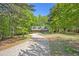Exterior home view showcasing the driveway and mature trees at 135 Fiddle Crk, Social Circle, GA 30025