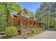 Beautiful log home with a long front porch, dormer windows, and a meticulously landscaped front yard at 135 Fiddle Crk, Social Circle, GA 30025