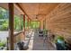 Cozy covered front porch featuring wood beams, ceiling fan, and comfortable seating at 135 Fiddle Crk, Social Circle, GA 30025