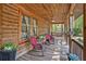 Relaxing covered front porch with wood ceiling and railing, ceiling fan and comfortable seating at 135 Fiddle Crk, Social Circle, GA 30025