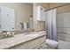Bathroom with granite countertop, cabinet storage, and shower with curtain at 2557 Summit Cove Dr # 128, Duluth, GA 30097