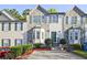 Charming townhome featuring stone accents, a well-manicured lawn, and a private driveway at 2557 Summit Cove Dr # 128, Duluth, GA 30097
