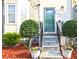 Close-up of a front door with manicured bushes and seasonal flowers in decorative pots at 2557 Summit Cove Dr # 128, Duluth, GA 30097