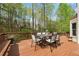 A back deck with outdoor table and chairs surrounded by mature trees and foliage at 3665 Evonvale Gln, Cumming, GA 30041