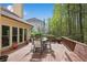 A back deck with outdoor table and chairs surrounded by mature trees and foliage at 3665 Evonvale Gln, Cumming, GA 30041