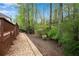 A stone path borders the back yard with lush greenery and mature trees, offering a sense of privacy and connection with nature at 3665 Evonvale Gln, Cumming, GA 30041