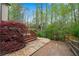 Backyard with a stone path leading to a deck overlooking mature trees and lush greenery creates a tranquil outdoor setting at 3665 Evonvale Gln, Cumming, GA 30041