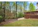 Back yard featuring a mulched flower bed and deck with lattice skirting surrounded by mature trees, provides an inviting outdoor space at 3665 Evonvale Gln, Cumming, GA 30041