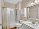 Bright bathroom featuring a shower-tub, vanity with framed mirror, and a matching toilet and cabinet at 3665 Evonvale Gln, Cumming, GA 30041