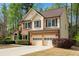 Side view of a brick and siding two-story home with mature trees and a two-car garage at 3665 Evonvale Gln, Cumming, GA 30041
