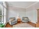 Cozy living room with two armchairs, hardwood floors, neutral paint, and wainscoting at 3665 Evonvale Gln, Cumming, GA 30041