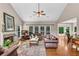 Bright living room featuring a fireplace, high ceilings, hardwood floors, and large windows with natural light at 3665 Evonvale Gln, Cumming, GA 30041