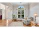 Inviting sitting room featuring hardwood flooring, wainscoting, and large window views at 3665 Evonvale Gln, Cumming, GA 30041