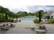 Outdoor community pool with lounge chairs, tables, umbrellas and mature landscaping at 3665 Evonvale Gln, Cumming, GA 30041