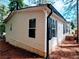 Side view of home exterior with beige siding, black shutters, and wooded surroundings at 3735 Fir Dr, Buford, GA 30518