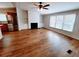 Spacious living room featuring wood floors, fireplace, ceiling fan and built in bookshelves at 3735 Fir Dr, Buford, GA 30518